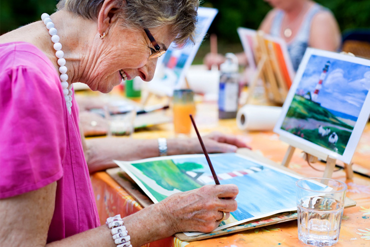 mullen residences senior woman painting in a class