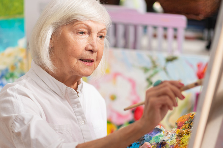 mullen residences senior woman painting a canvas